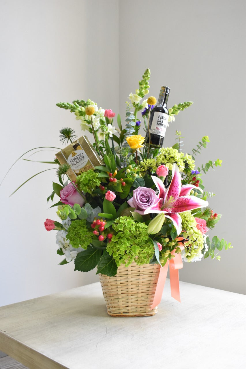 Canasta de flores con vino y chocolates