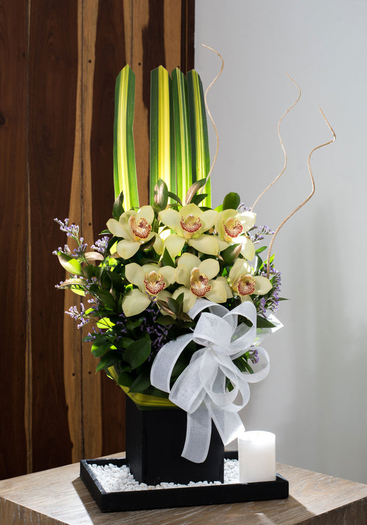 Arreglo floral base madera negra orquideas con velon